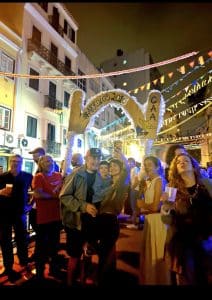 Residents and visitors enjoying a neighborhood festival during Lisbon's Popular Saints celebrations.