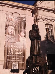 Church of Saint Anthony in Lisbon marking the traditional birthplace of Saint Anthony, with a statue of the saint in the foreground.