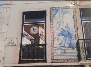 Street sign reading Rua do Milagre de Santo António beside a traditional Portuguese tile panel depicting Saint Anthony.